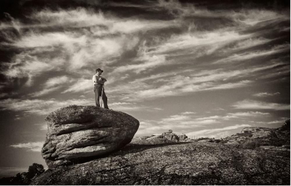 photograph of man standing on boulder in deep thought by artist David Arruda, Jr.